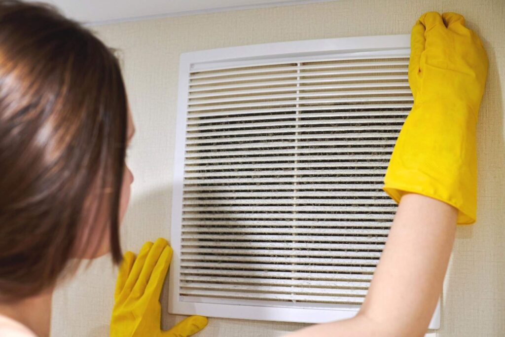 woman-holding-ventilation-grill-of-hvac-for-cleaning